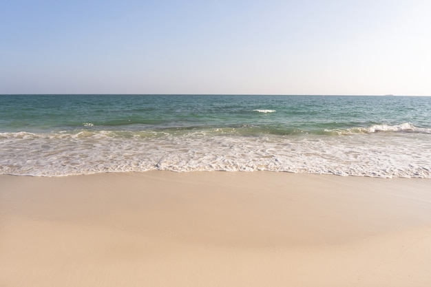 Praia e ondas do mar tropical com céu azul sobre fundo de dia ensolarado. copie o espaço