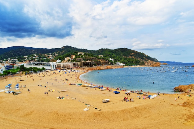 Praia e pessoas em Tossa de Mar, na Costa Brava, no Mar Mediterrâneo, na Espanha.