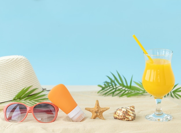 Praia ensolarada com acessórios de verão, copo de suco de laranja, chapéu, óculos escuros, concha de protetor solar e estrela do mar