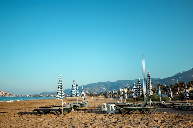 Praia matinal, espreguiçadeiras para recreação, mar. férias de conceito, descanso, passeio no navio.