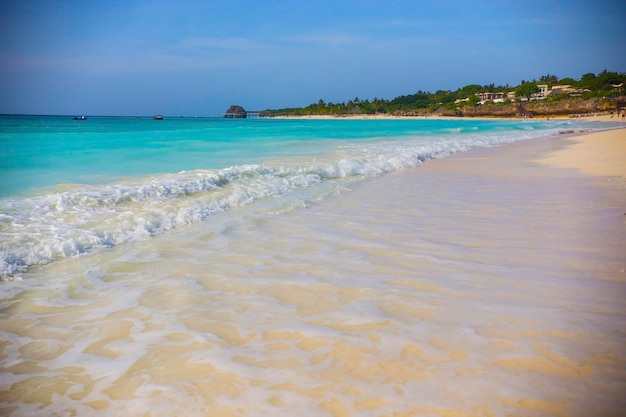 Praia paradisíaca com água turquesa e barco a vela no mar, vila de Nungwi, Zanzibar, Tanzânia