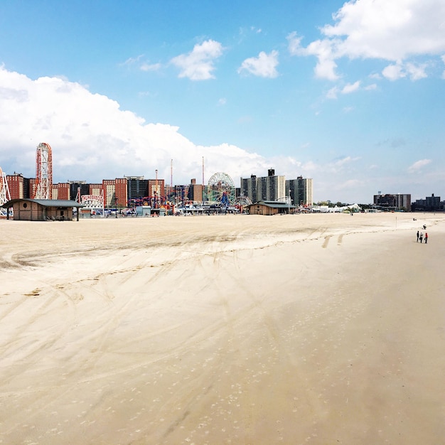 Praia por edifícios contra o céu em Coney Island