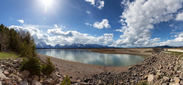 Praia rochosa à beira do lago com montanhas na temporada de primavera de fundo