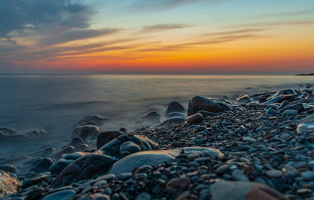 Praia rochosa ao pôr do sol lindas cores nas rochas