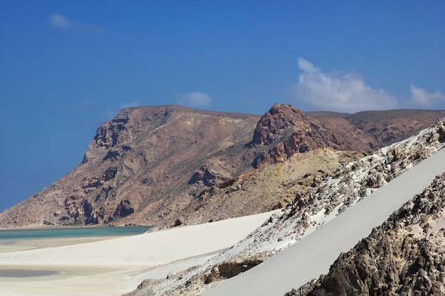 Praia rochosa com montanhas