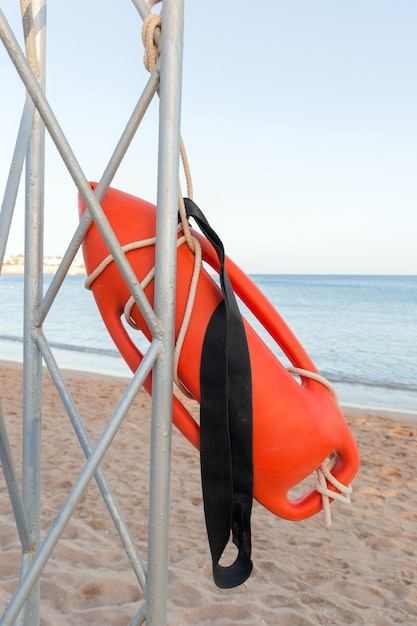 Praia salva-vidas. Torre da salva-vidas com a boia alaranjada na praia.