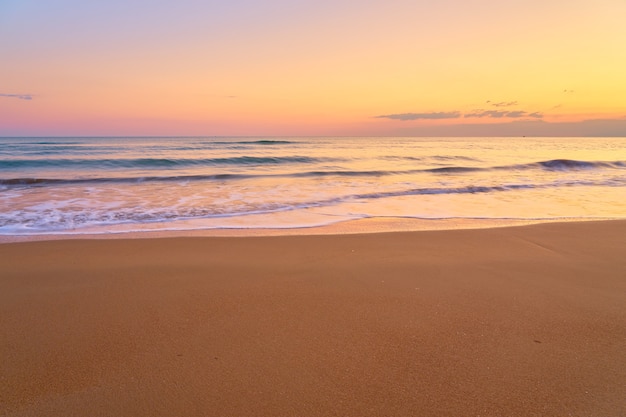 Praia tropical de areia ao pôr do sol