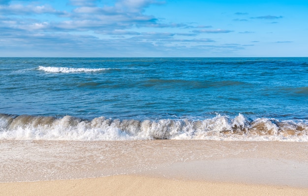 Foto praia vazia com areia amarela e ondas azuis, quarentena no resort