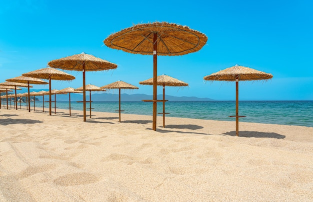 Praia vazia com guarda-sóis de madeira no mar Mediterrâneo