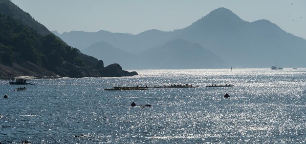 Praia Vermelha no bairro da Urca no Rio de Janeiro Brasil Amanhecer com barcos de pescadores no mar e colinas ao fundo Luz de fundo com objetos em silhueta