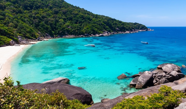 Praias tropicais têm água azul clara e quente e fundo de céu azul ou paisagens nas Ilhas Similan