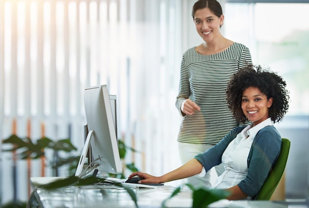 Praktikantin oder neue Mitarbeiterin mit ihrem Vorgesetzten oder Personalleiter im Büro Porträt von glücklich lächelnden und ehrgeizigen Geschäftsfrauen und Kollegen an einem Schreibtisch bei der Arbeit