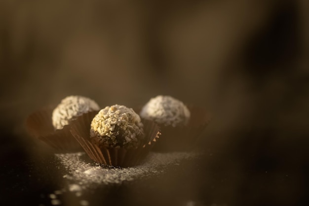 Pralinen in Streusel auf dunklem Hintergrund mit verschwommenem heißem Dampf im Vordergrund