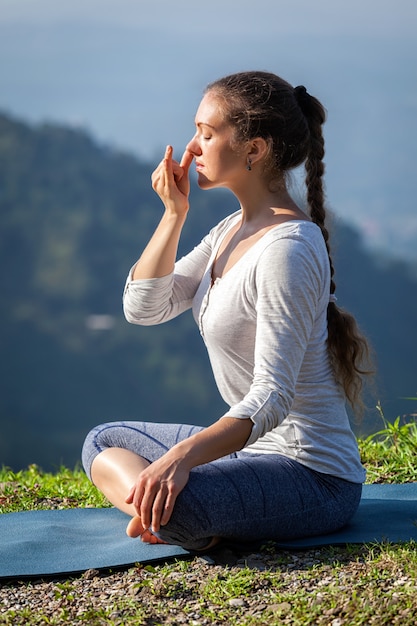 Pranayama de práticas de mulher em pose de lótus ao ar livre