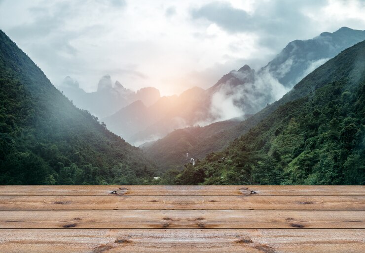 Foto prancha de madeira na cordilheira com cena de nevoeiro e efeito de luz do sol