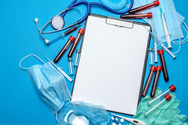 Prancheta com folha de papel em branco com ferramentas médicas em azul