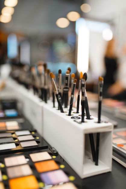 Prateleira com sombras e pincéis em loja de cosméticos, ninguém. salão de beleza de luxo, vitrine com produtos no mercado da moda