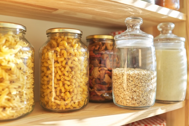 Foto prateleiras de madeira na despensa para armazenamento de alimentos, grãos em potes de armazenamento