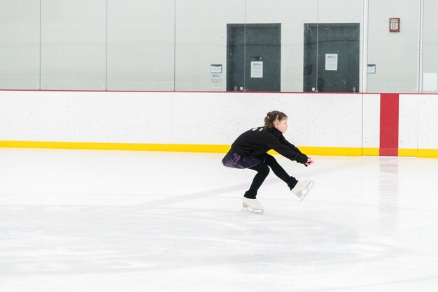 Foto prática de patinação artística em um rinque de patinação indoor