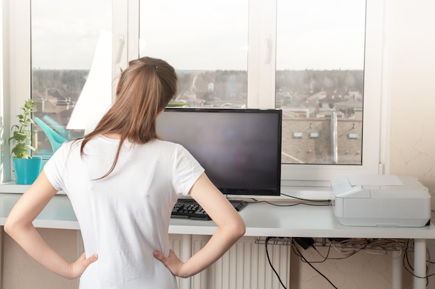 Praticando esportes em casa jovem fazendo exercícios olhando para o monitor