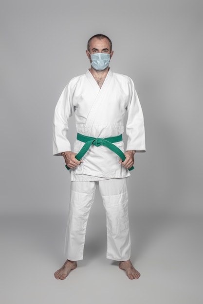 Foto praticante de artes marciais usando uma máscara para se proteger da infecção covid-19