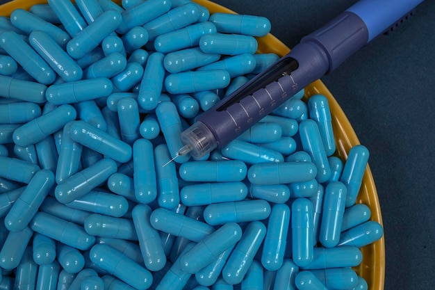 Prato amarelo cheio de cápsulas de medicamentos azuis representando overdose de droga
