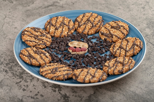 Foto prato azul de biscoitos de aveia com amendoim orgânico na mesa.