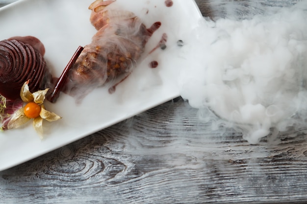 Prato branco com carne cozida prato de carne com decoração peito de pato e pau de canela tradicional eu ...