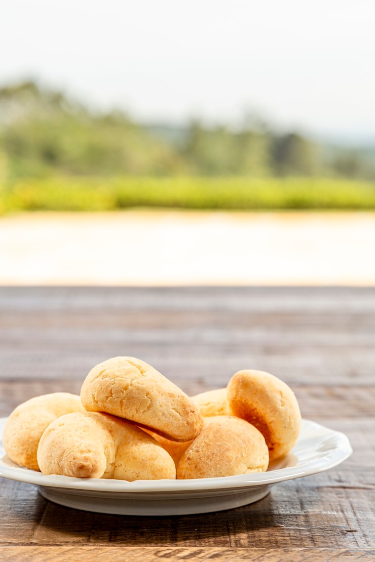 Foto prato branco com queijo chipa, em uma foto vertical de mesa de madeira rústica