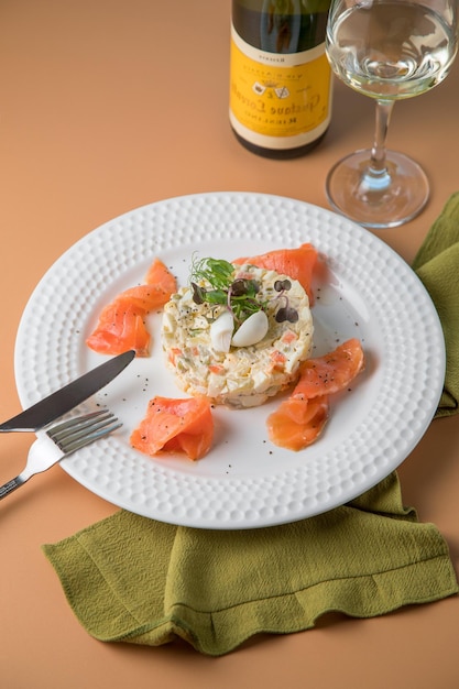 Prato branco e peixe defumado com refeição de prato de risoto e mão de mulher Salada de vegetais de folha