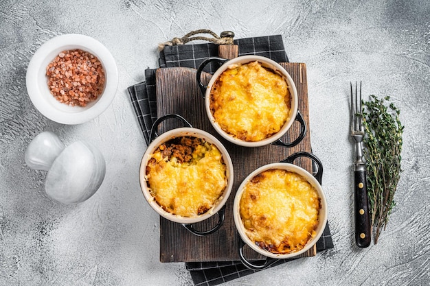 Prato britânico Torta de pastor com carne moída, purê de batata e crosta de queijo cheddar. Fundo branco. Vista do topo.