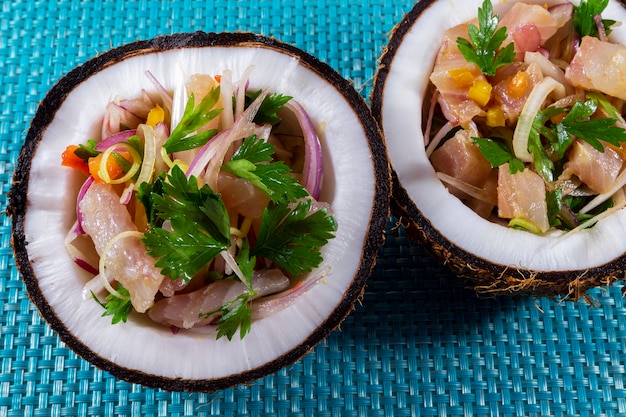 Prato ceviche - aperitivo de peixe fresco marinado em citrinos com frutas tropicais servido em coconut bowls.
