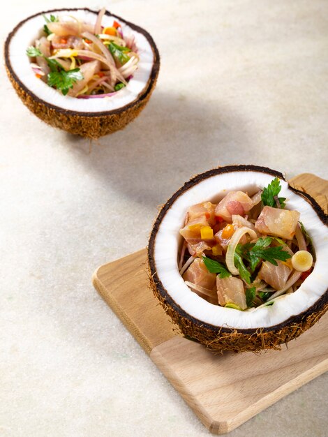 Prato ceviche - aperitivo de peixe fresco marinado em citrinos com frutas tropicais servido em coconut bowls.