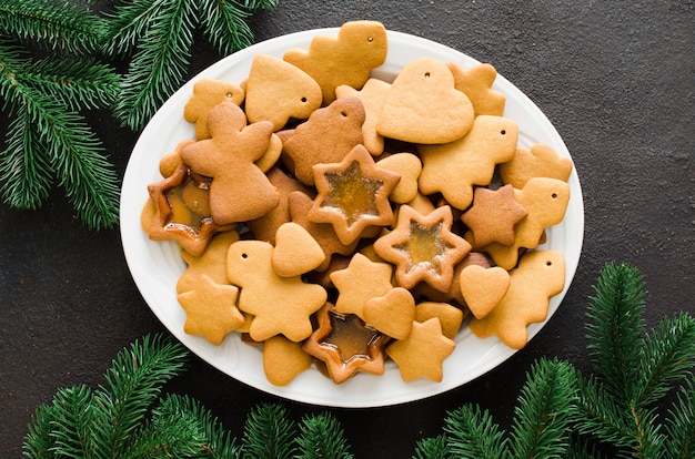 Prato cheio de pão de natal recém-assados pronto para decorar com glacê.