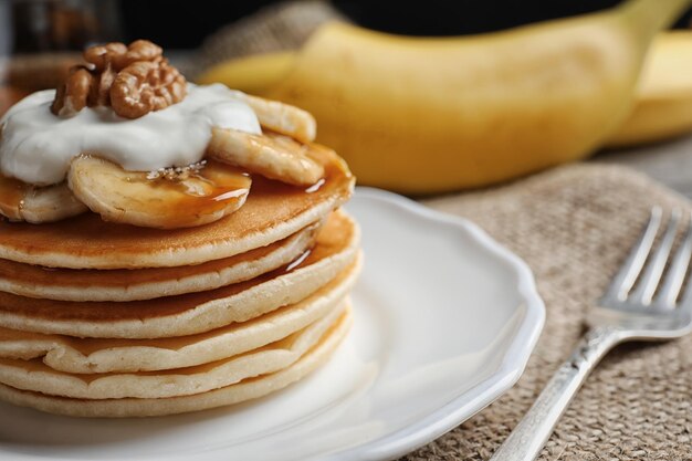 Prato com deliciosas panquecas de banana na mesa da cozinha