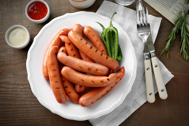 Prato com deliciosas salsichas grelhadas na mesa