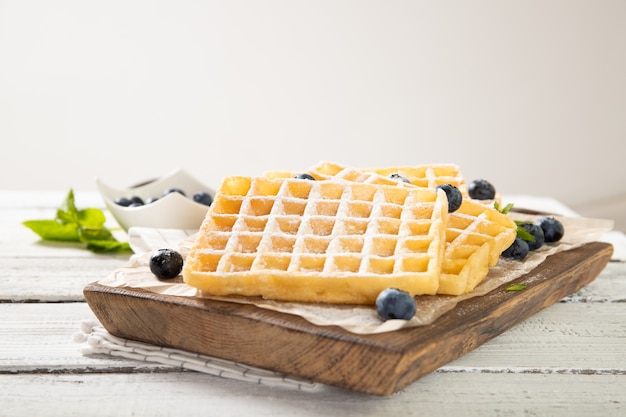 Prato com deliciosos waffles belgas tradicionais com mirtilos frescos. Lugar para texto