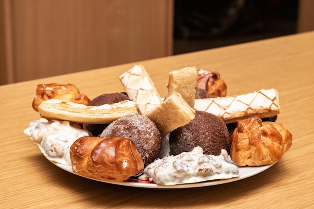 Prato com diferentes biscoitos e bolo em uma mesa de madeira