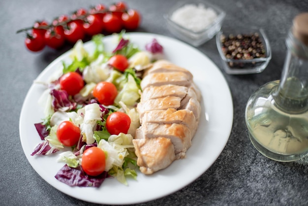 prato com filé de frango e salada com legumes em um fundo de pedra