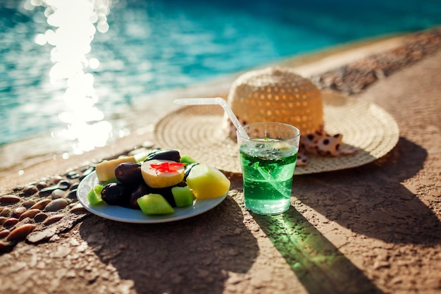 Prato com frutas exóticas e bebida à beira da piscina Férias de verão Tudo incluído