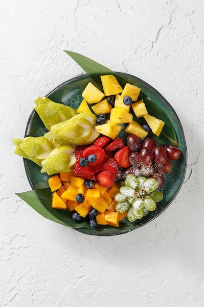 Prato com frutas frescas isoladas no fundo branco de concreto