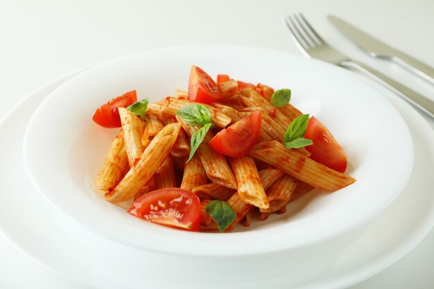 Prato com macarrão com molho de tomate no fundo branco