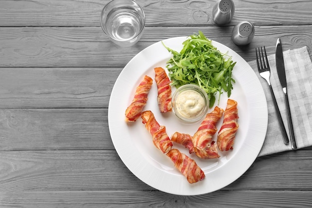 Prato com nuggets de frango embrulhados em bacon na mesa