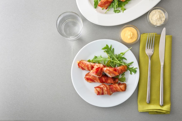 Prato com nuggets de frango embrulhados em bacon na mesa