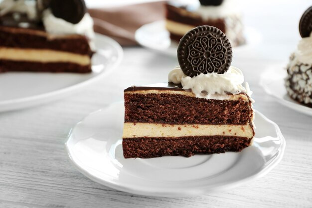 Prato com pedaço de bolo de chocolate saboroso na mesa de madeira