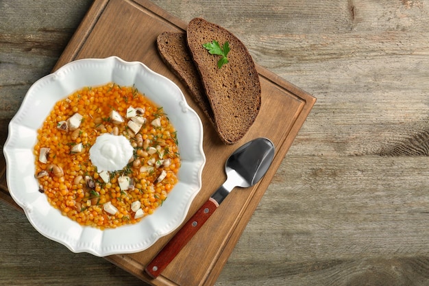 Prato com saborosa sopa de lentilha na tábua de madeira