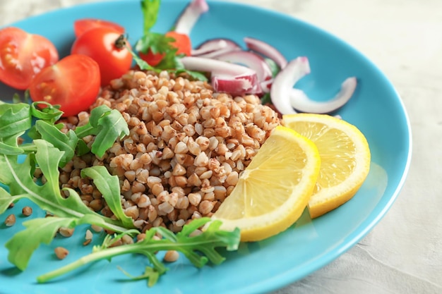 Foto prato com saboroso mingau de trigo sarraceno e legumes na mesa closeup