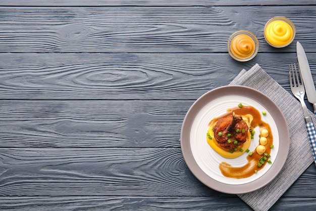 Foto prato com saboroso pirulito de frango em superfície de madeira escura