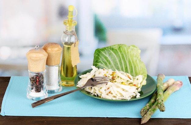 Prato com salada de repolho e temperos na mesa de madeira no fundo da sala