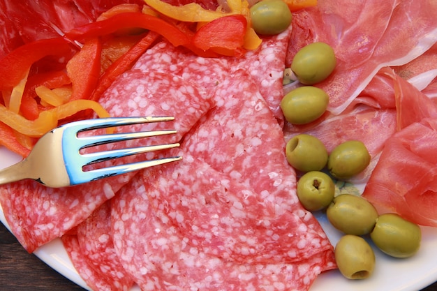 prato com salame, presunto e aperitivos